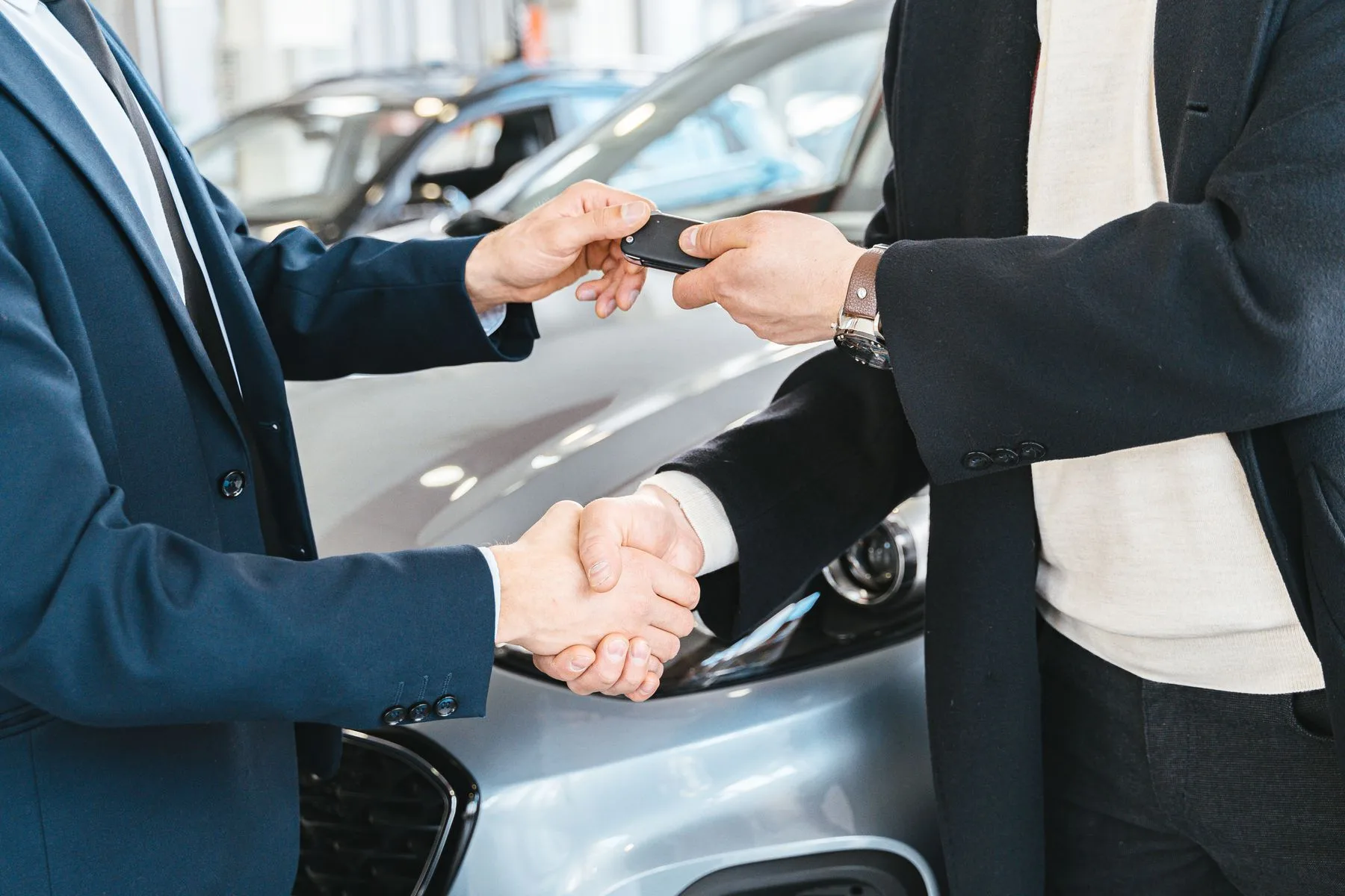 Aperto de mão e entrega da chave do carro ao lado do veículo